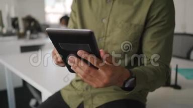 <strong>现代</strong>办公室里，年轻商人穿着衬衫坐在白色<strong>办公桌</strong>上，用数码平板电脑做特写
